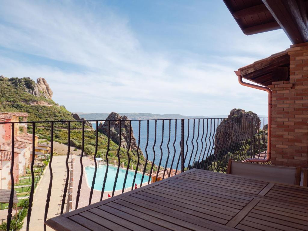 a balcony with a view of a pool and mountains at La Casa Del Mare Tanca Piras in Nebida