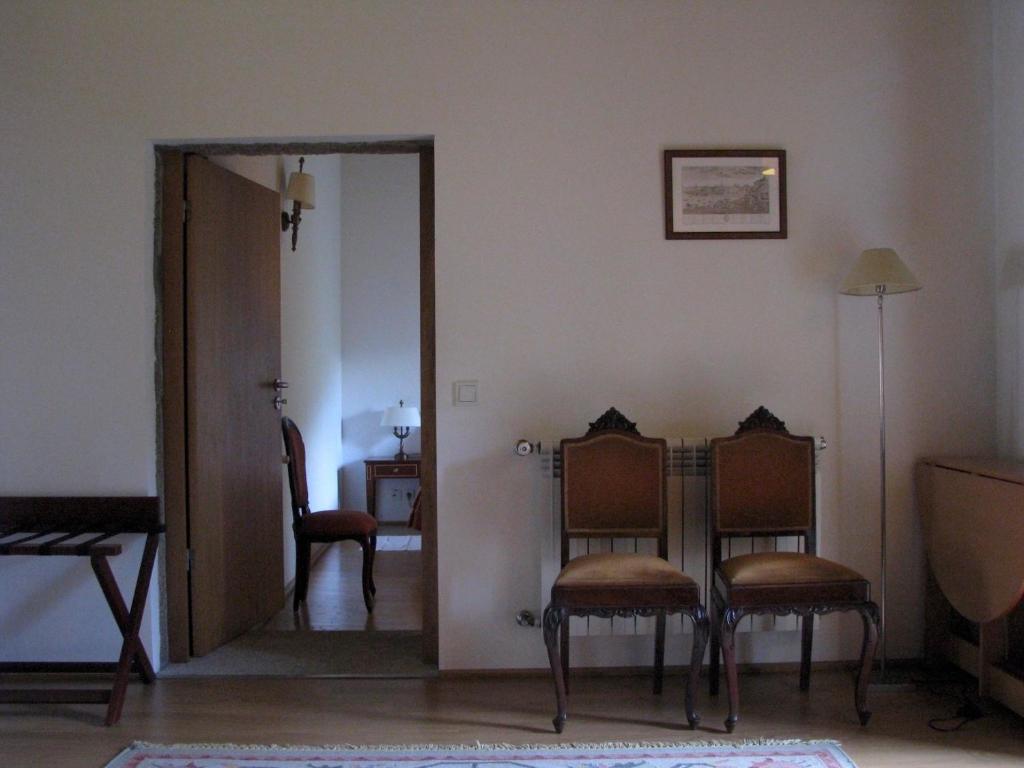 a living room with two chairs and a mirror at Mosteiro De S. Cristovao De Lafoes in São Cristóvão de Lafões