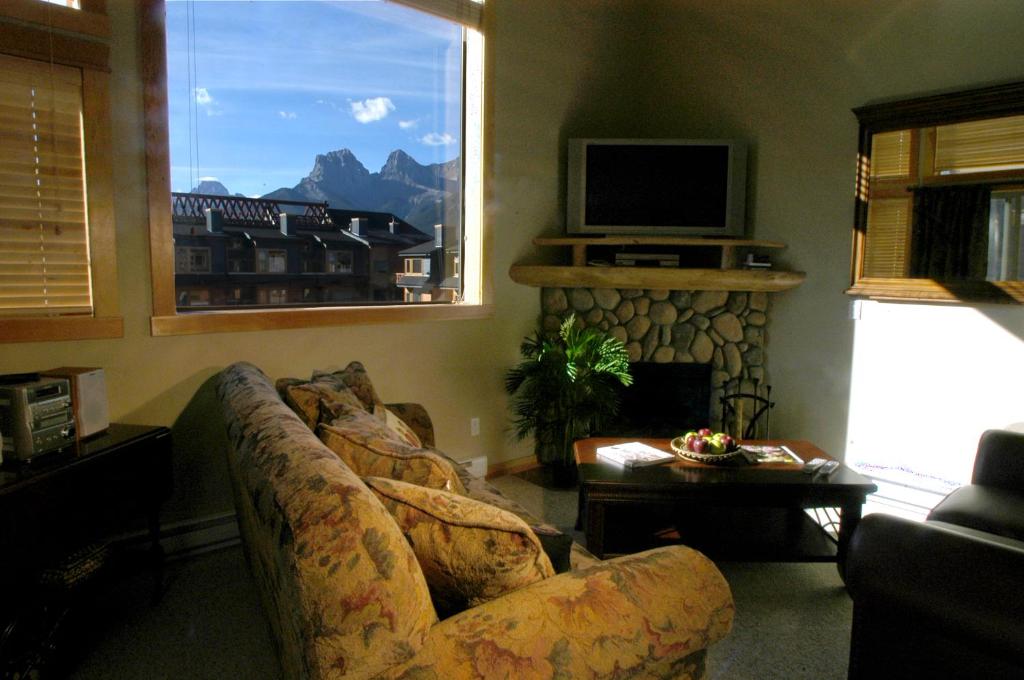 un soggiorno con divano e camino di Apartment 411, Antique Heritage a Canmore
