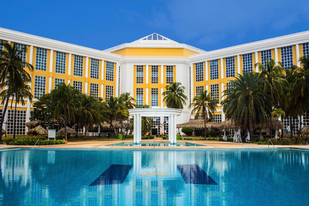 - un grand bâtiment avec une grande piscine en face dans l'établissement Hesperia Isla Margarita, à La Playa