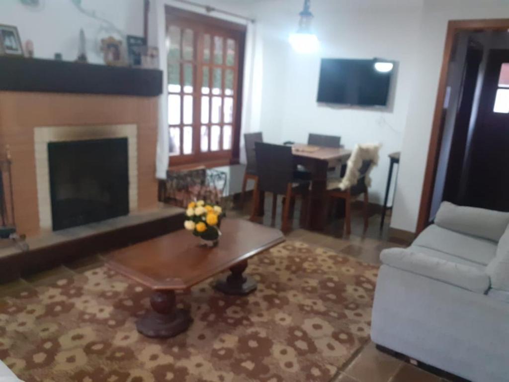a living room with a couch and a fireplace at Casa no Capivari in Campos do Jordão