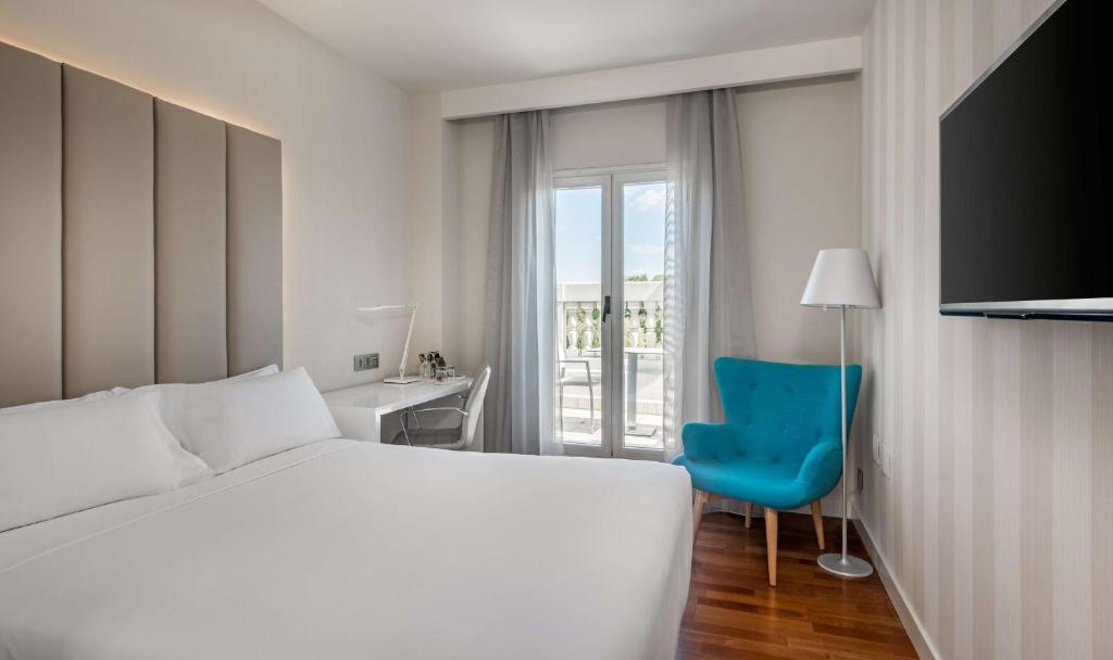 a hotel room with a bed and a television at NH Madrid Nacional in Madrid