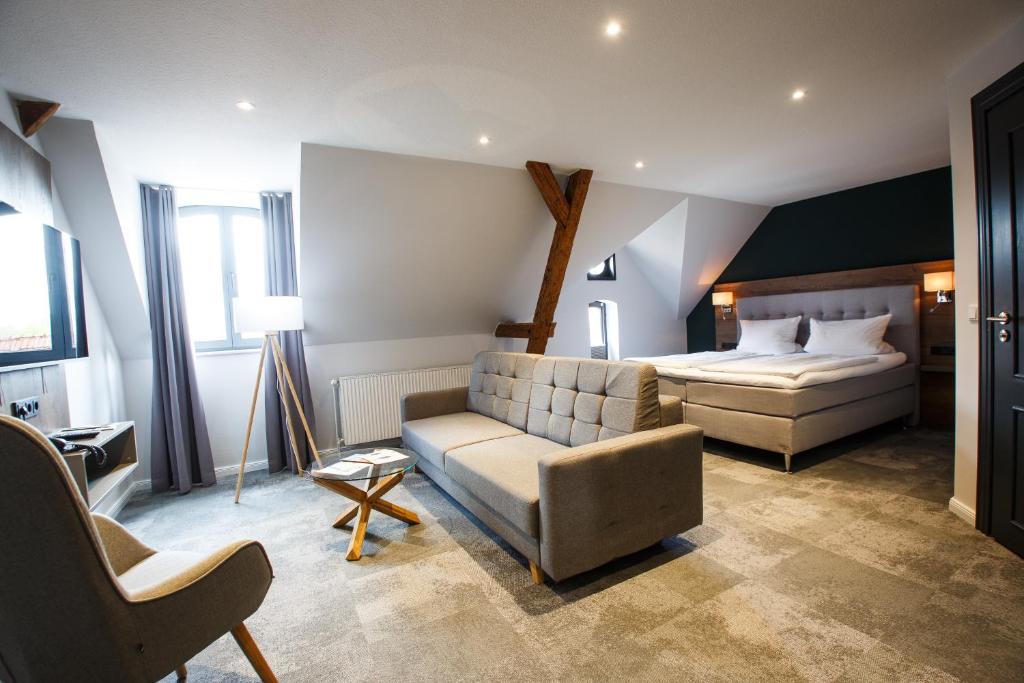 ein Wohnzimmer mit einem Bett und einem Sofa in einem Zimmer in der Unterkunft Romantik Hotel Aquarium in Friedrichstadt