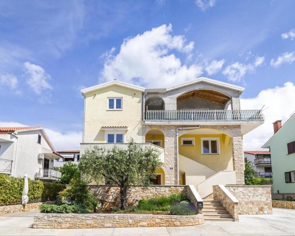 a large house with a staircase in front of it at Apartments Balach in Poreč