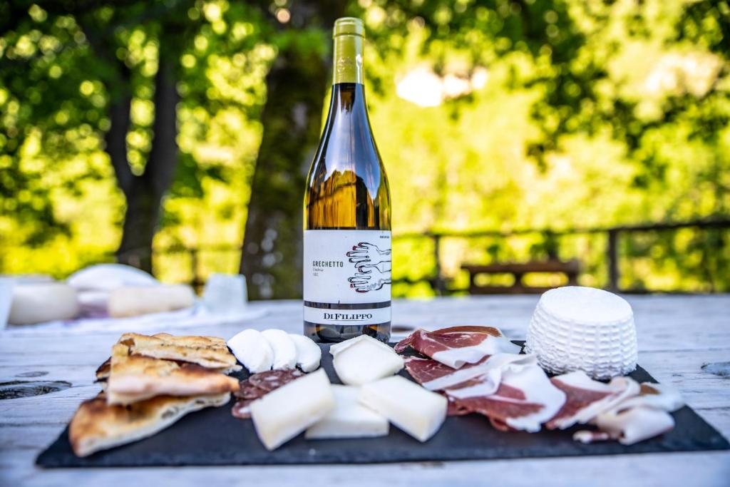 butelka wina siedząca na stole z jedzeniem w obiekcie Agriturismo le due querce w mieście Cerreto di Spoleto