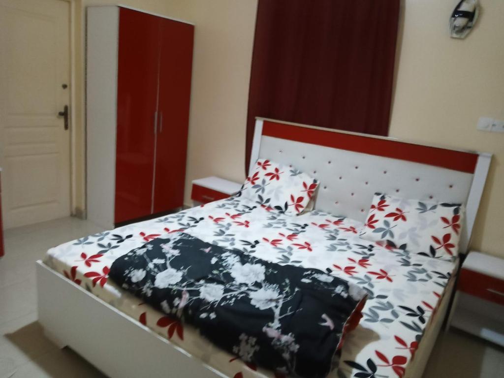 1 dormitorio con 1 cama con edredón blanco y negro en Résidence Fadi Diamniadio en Dakar