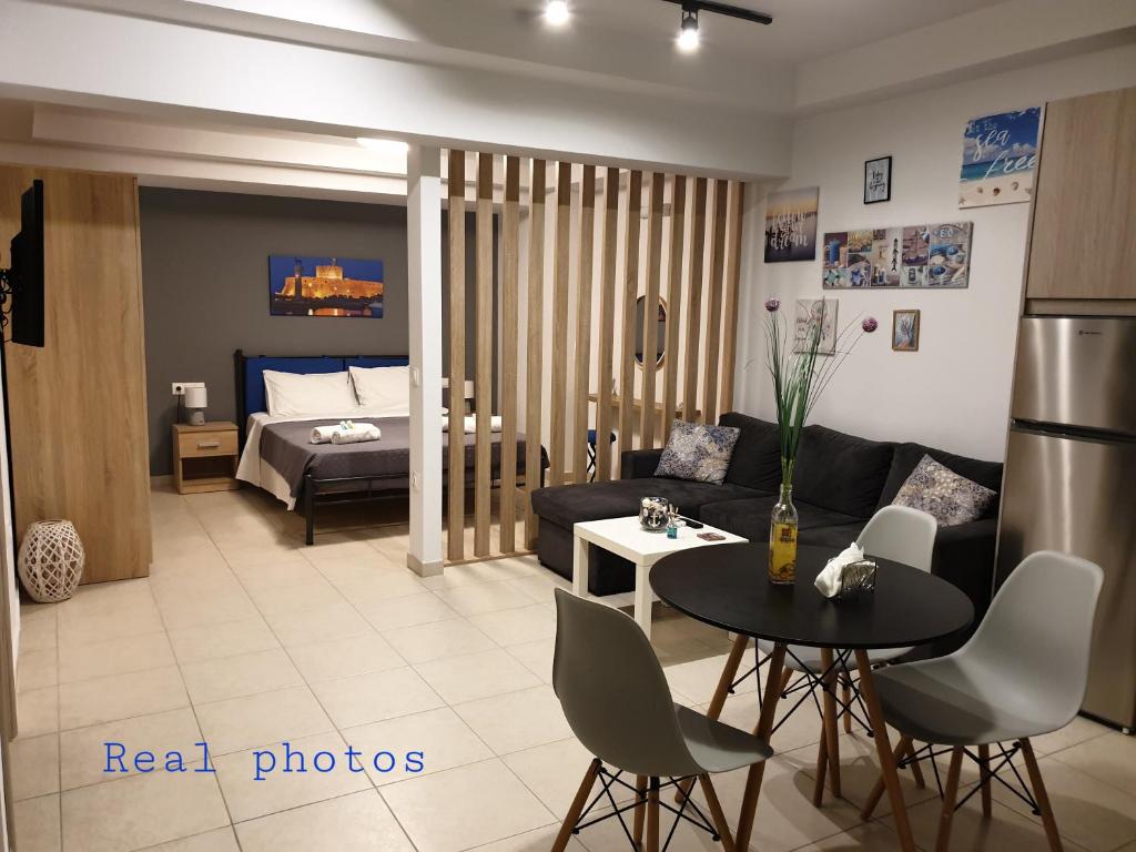 a living room with a couch and a table at comfy center rodos - blue in Asgourou