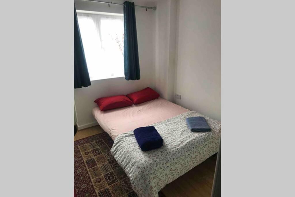 uma pequena cama num quarto com uma janela em Private Studio home away from home ... em Hackbridge