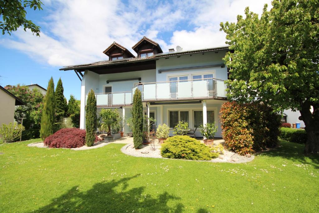 a large white house with a balcony on a yard at Appartementhaus Sonneneck in Bad Füssing