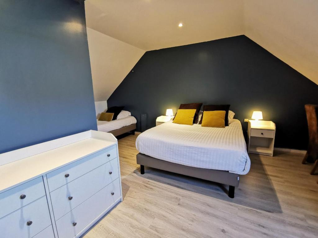 een slaapkamer met een groot bed en een zwarte muur bij Hôtel Restaurant Le Mulberry Arromanches in Arromanches-les-Bains