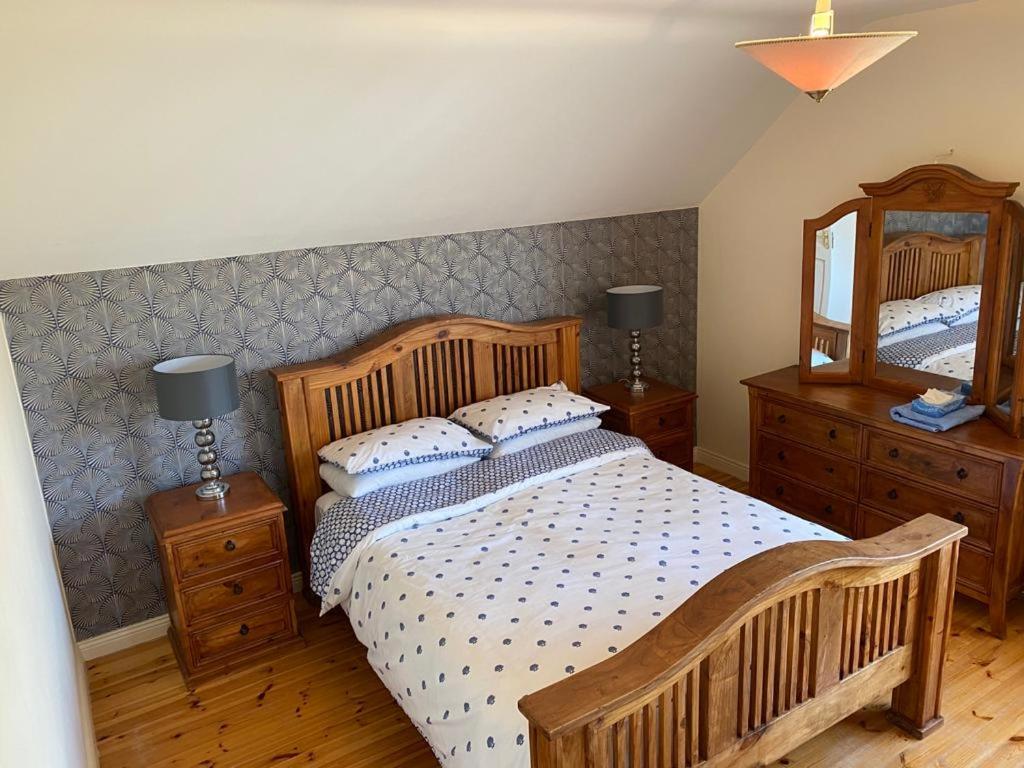 a bedroom with a large wooden bed and a mirror at Holiday Home Waterville in Waterville