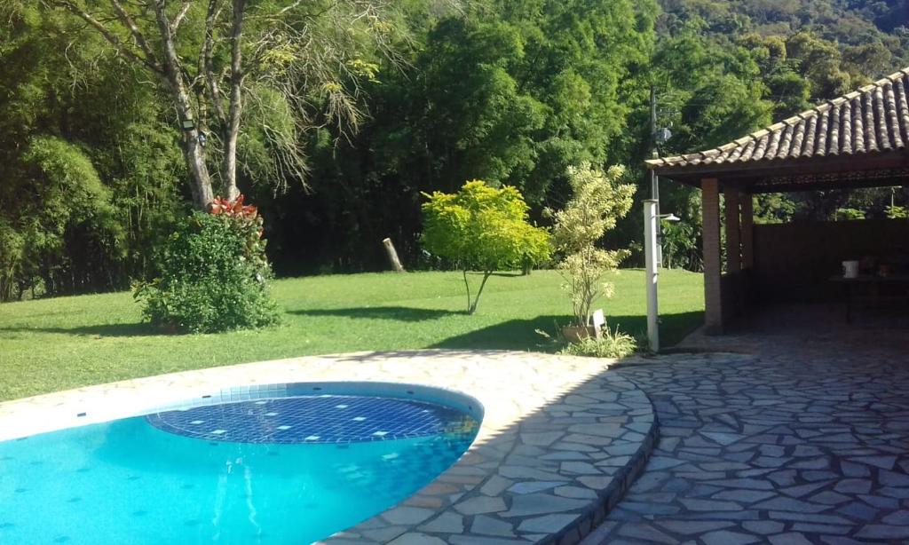 een zwembad in de tuin van een huis bij Recanto beira rio in Sana