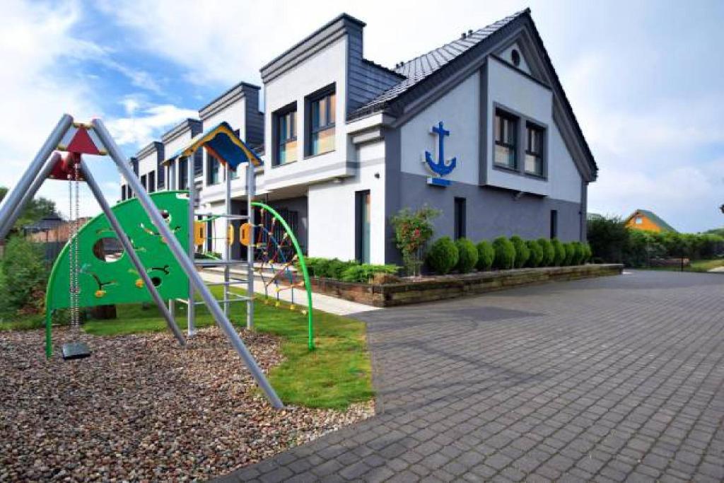 a playground in a yard in front of a house at Apartamenty Kormoran in Sarbinowo