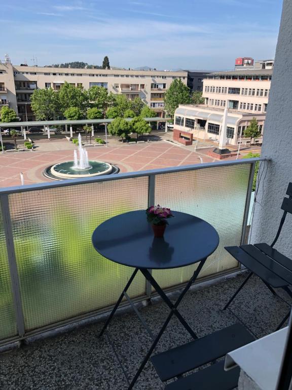 a table and chairs on a balcony with a fountain at Square apartment Podgorica in Podgorica