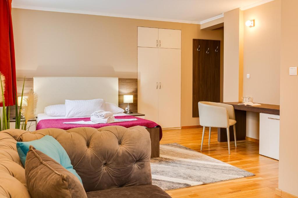 a living room with a couch and a bed at Hotel Sky in Zadar