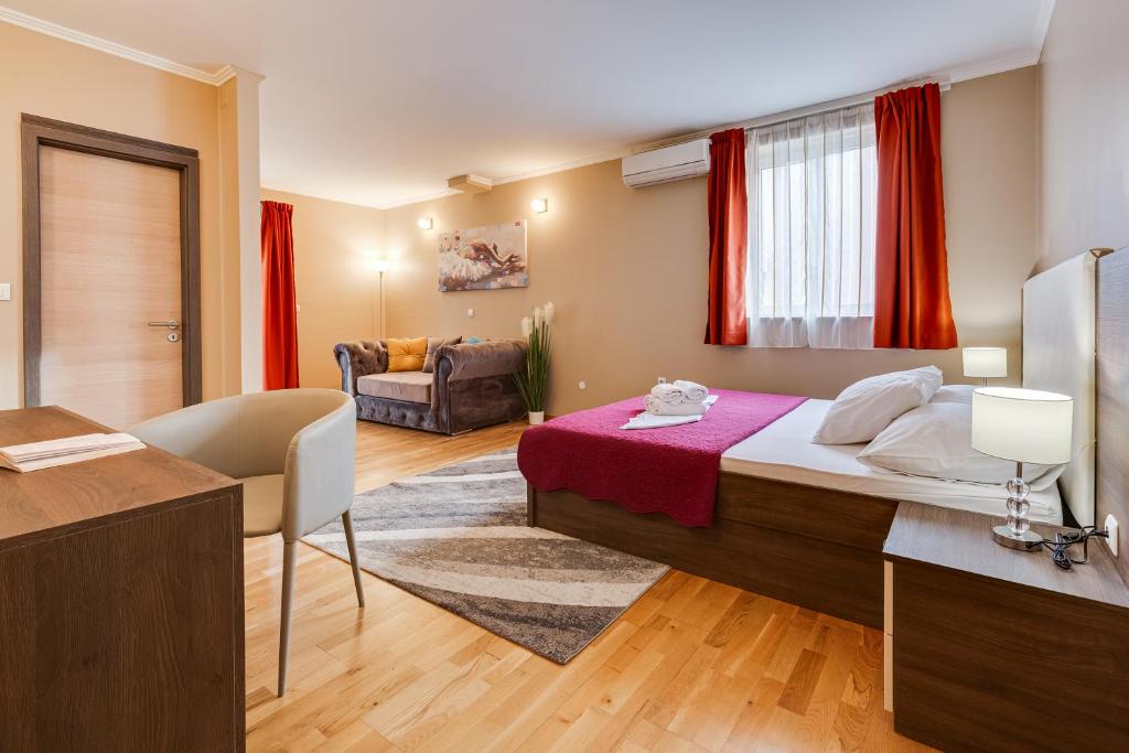 a bedroom with a bed and a living room at Hotel Sky in Zadar