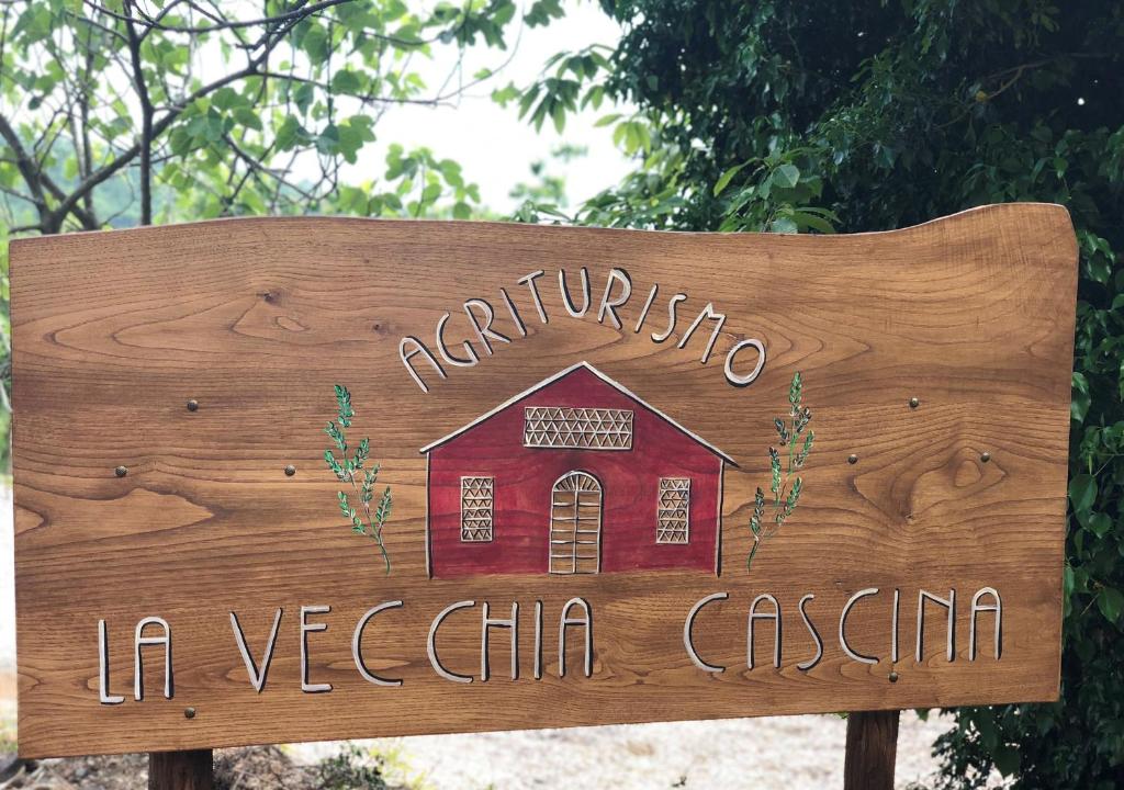 a wooden sign with a red barn on it at Agriturismo LA VECCHIA CASCINA in Filattiera
