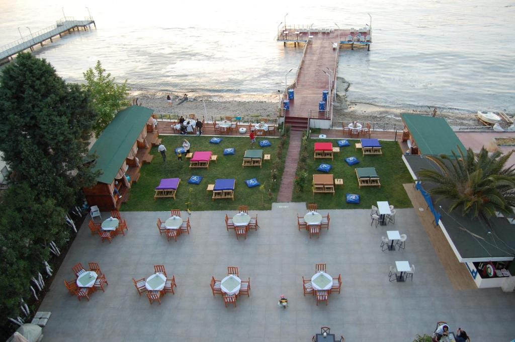 an overhead view of a patio with tables and chairs near the ocean at Grand Koru Hotel Beach in Yalova