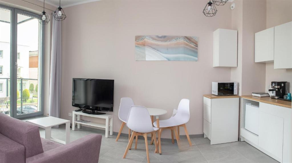 Una cocina y una sala de estar con mesa y sillas. en APARTAMENTwPUCKu, en Puck