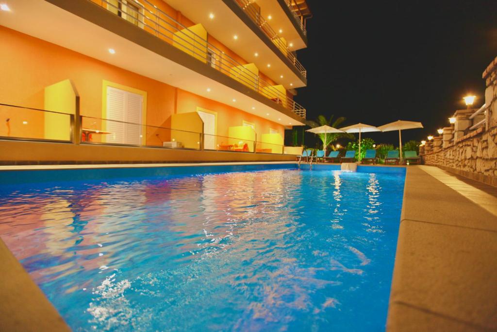 una piscina en un edificio por la noche en Karos Hotel Llaman, en Himare