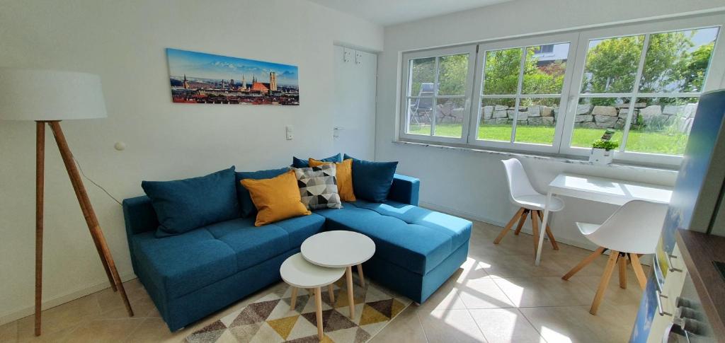 a living room with a blue couch and a table at Apartment Charly - Aktivurlaub im Herzen Bayerns in Wolfersdorf