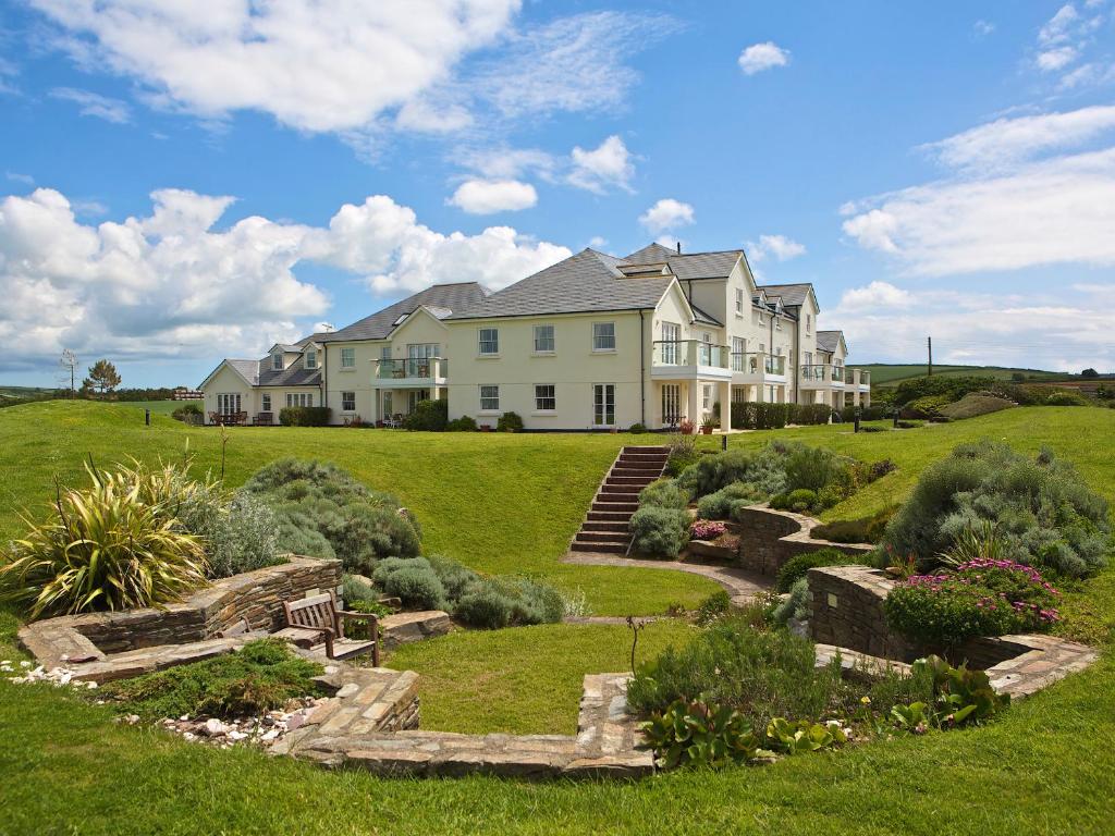 a large house on a hill with a garden at Ocean View Apartment in Thurlestone