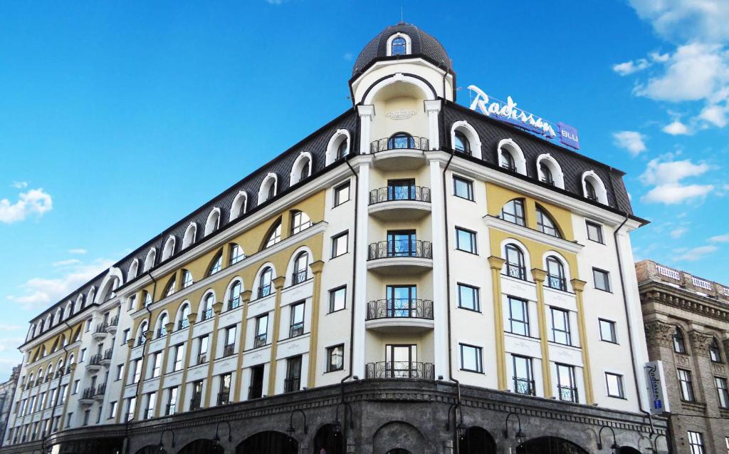 un edificio con una torre dell'orologio sopra di Radisson Blu Hotel, Kyiv Podil City Centre a Kiev