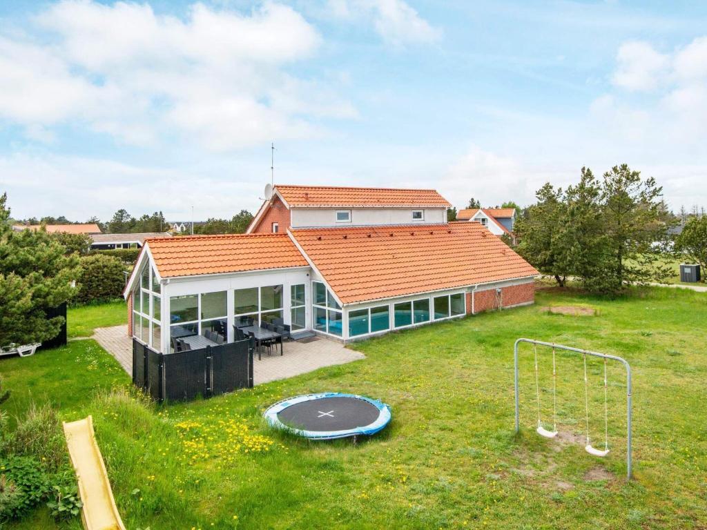 een huis met een grote tuin met een trampoline bij 12 person holiday home in Glesborg in Fjellerup Strand