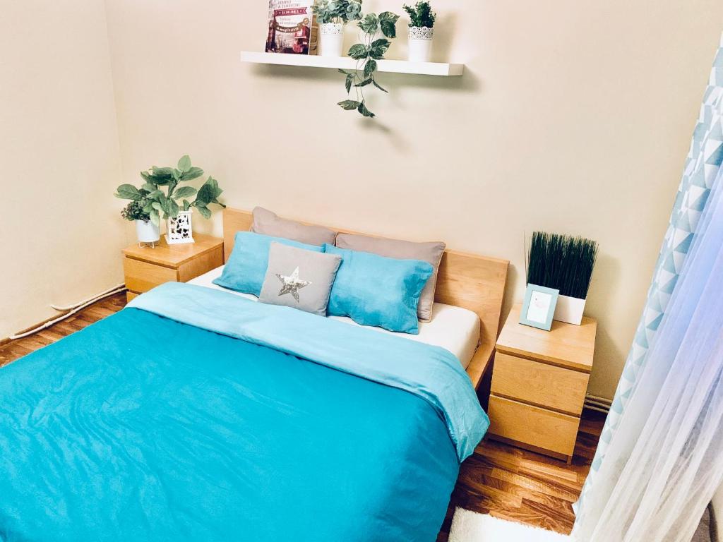 una camera da letto con letto con lenzuola e cuscini blu di Boulevard rose a Alba Iulia