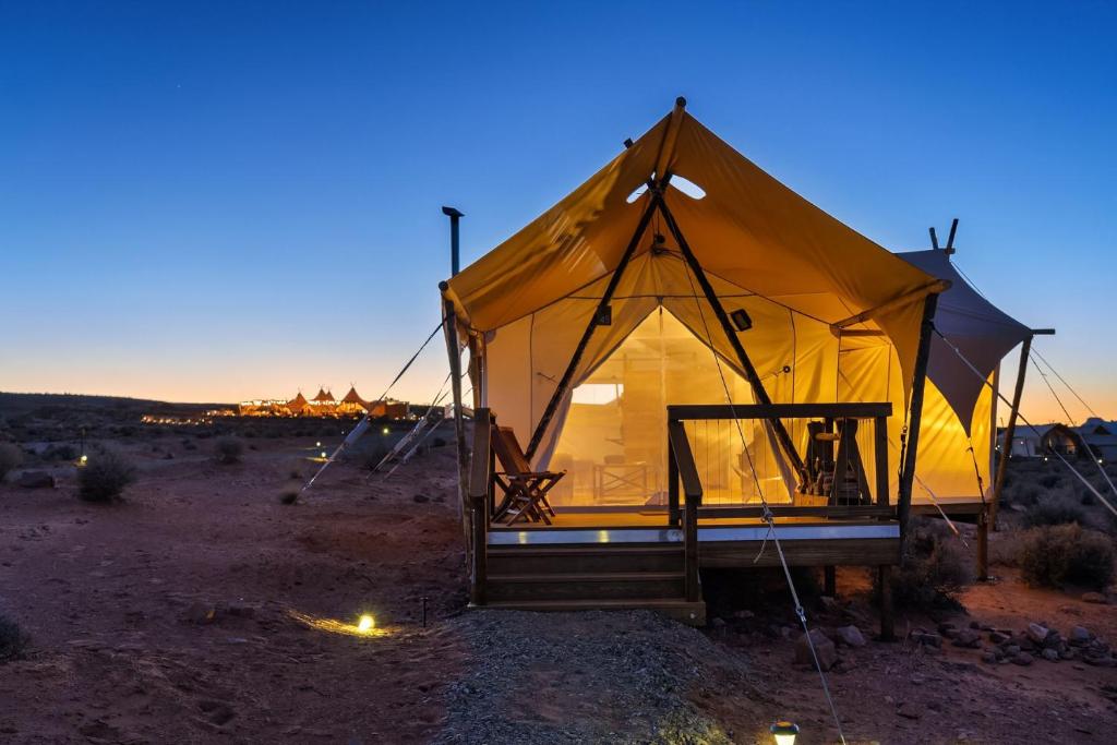 a large yellow tent in the desert at night at Under Canvas Lake Powell-Grand Staircase in Big Water