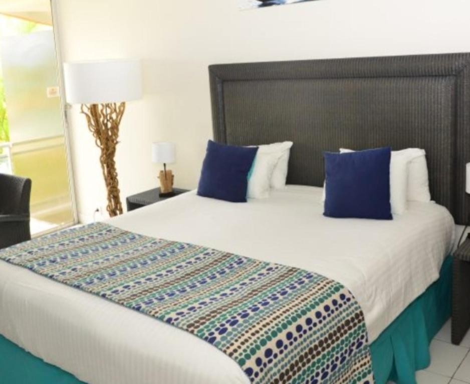 een slaapkamer met een groot bed met blauwe kussens bij Divijuka in Taganga