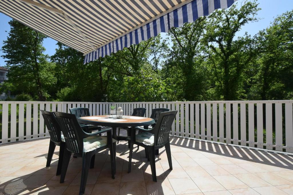 a table and chairs on a patio with a white fence at Apartment Lorela in Malinska