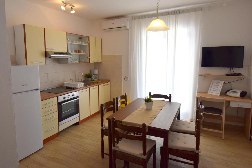 a kitchen with a wooden table and a kitchen with a dining room at Apartment Lorela in Malinska