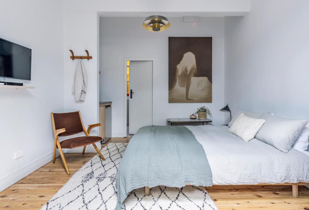 a bedroom with a large bed and a chair at Bondi Beach House in Sydney
