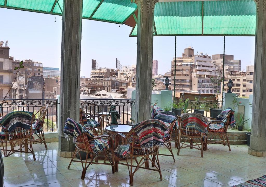 a patio with chairs and tables with a view of a city at Cecilia Hostel in Cairo