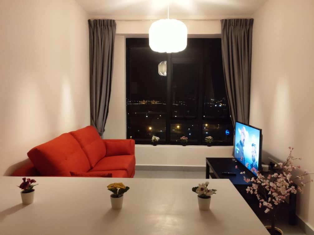 a living room with an orange couch and a window at Cozy Studio unit,Cyberjaya,Wifi, Netflix,Free parking in Cyberjaya