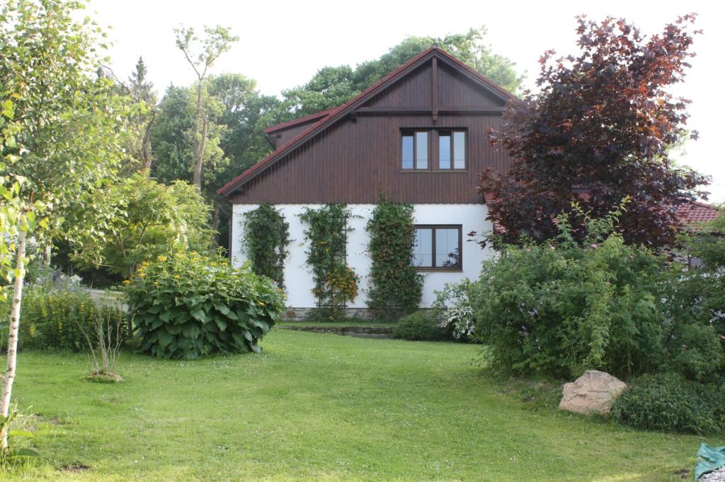 een wit huis met een bruin dak en een tuin bij Luxury Apartment in Sumava Mountains in Křišťanov