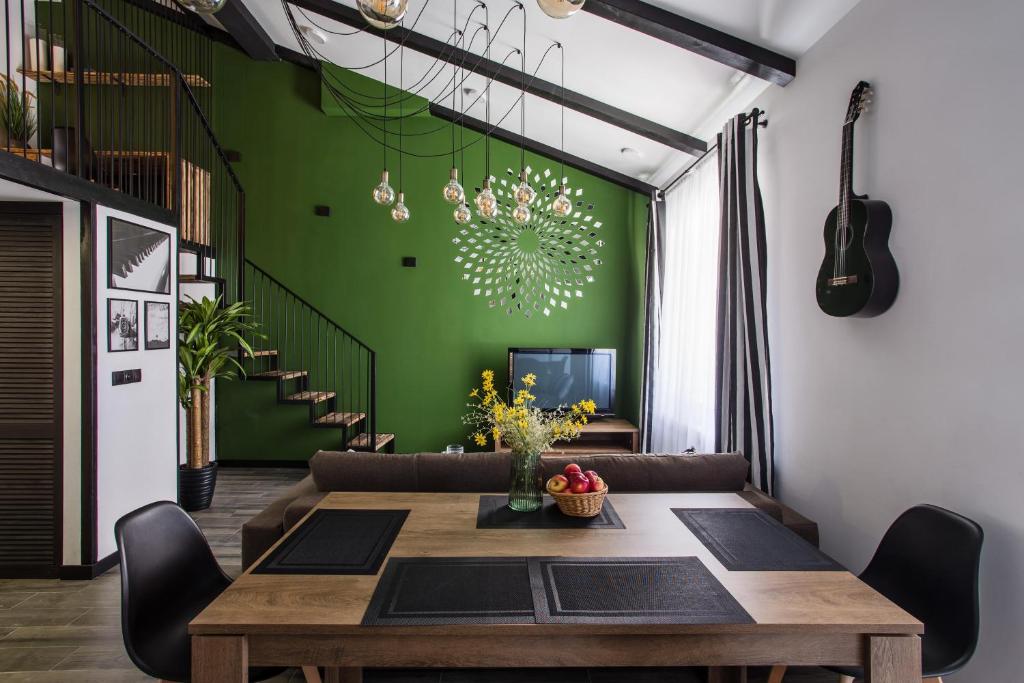 a dining room with a table and a green wall at Двухуровневая квартира Черноморск для 5 человек in Chornomorsk