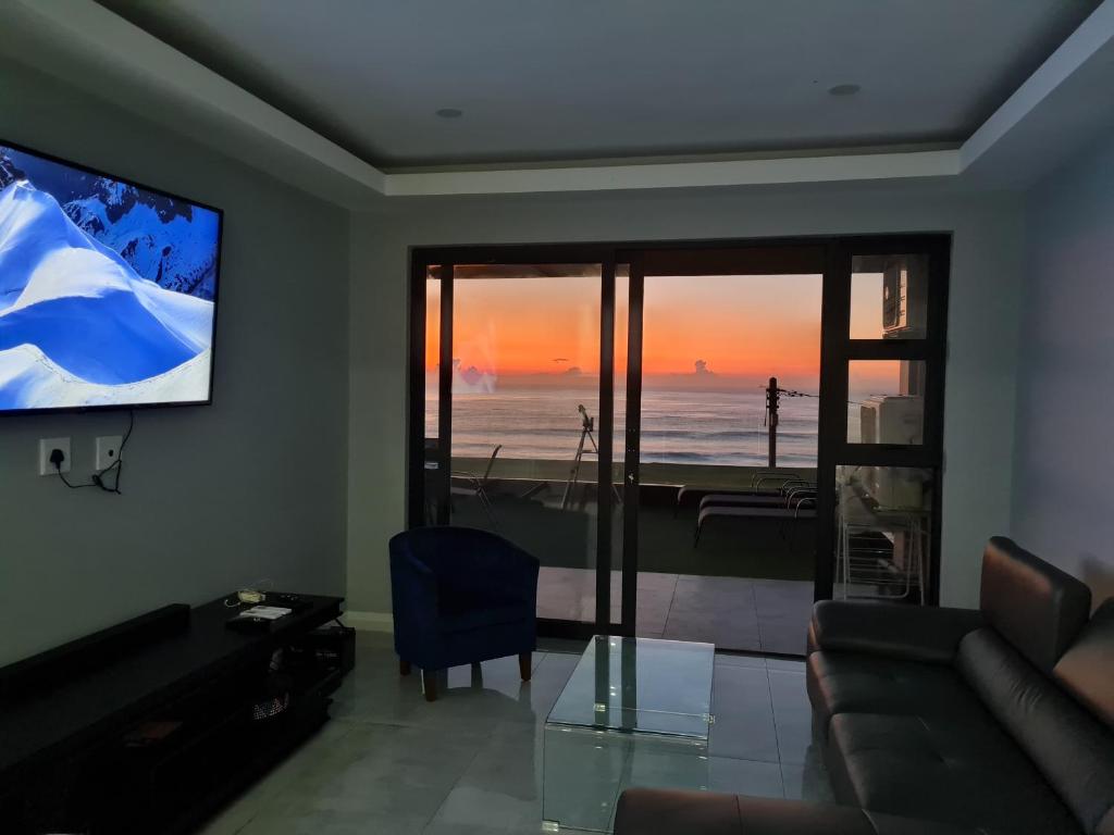a living room with a view of the ocean at Qophelo Sea Views in La Mercy