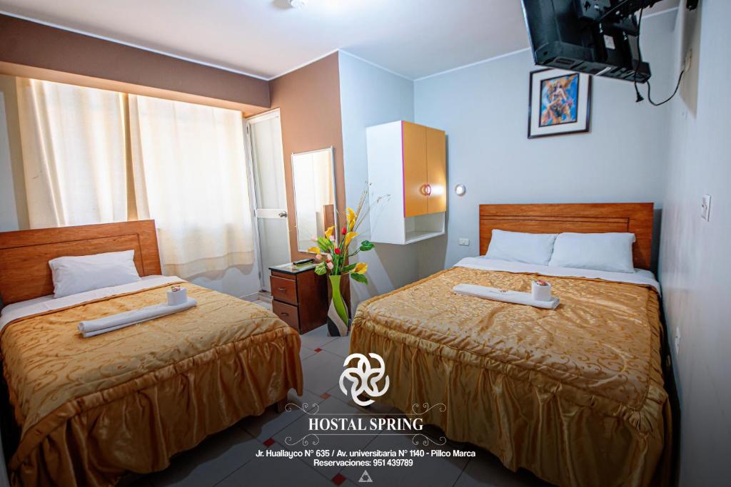 瓦努科的住宿－Hostal Spring II，酒店客房设有两张床和电视。
