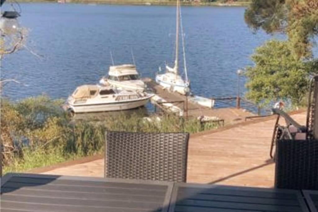 a table and chairs with boats in the water at Exclusive House in Steninge Marina , Märsta in Märsta