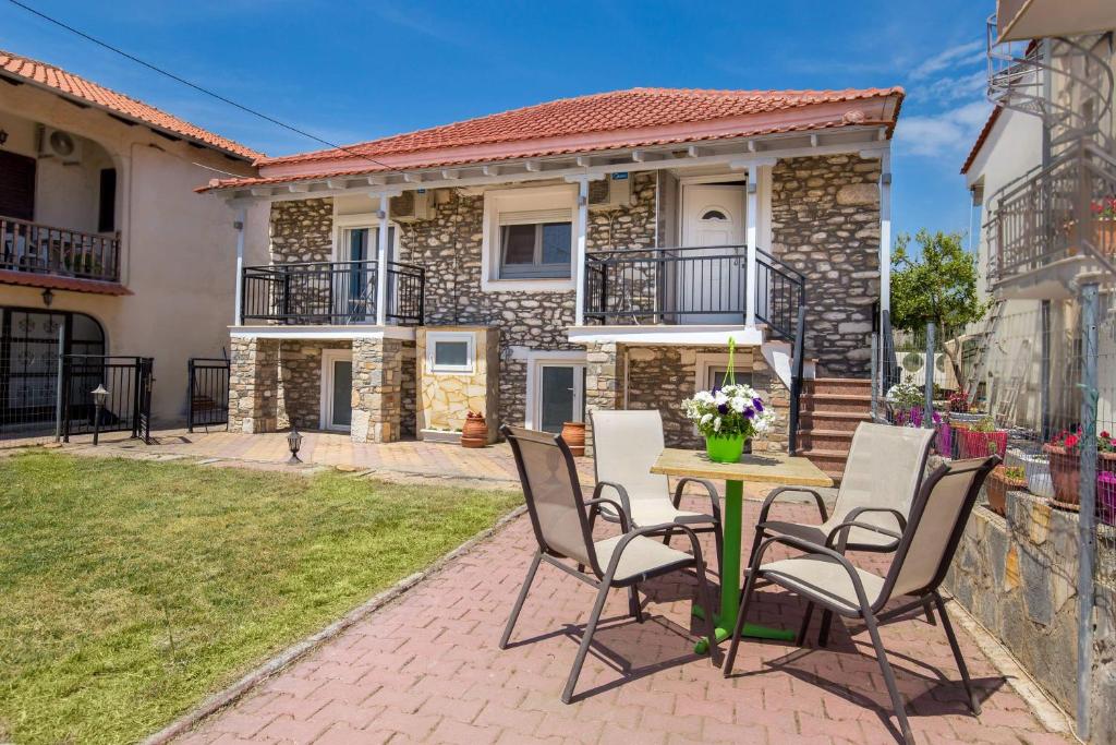 un patio con mesa y sillas frente a una casa en Lena Apartments II en Limenaria