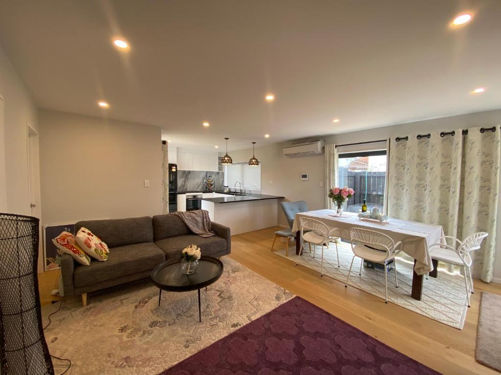 a living room with a couch and a table at Auckland Cornwall Park holiday Home in Auckland