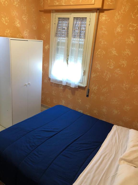 a bedroom with a blue bed and a window at La veranda in Ardea