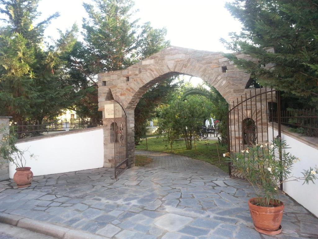 un ingresso a un edificio in pietra con cancello di To Portego tis Anatolis a Néa Péramos