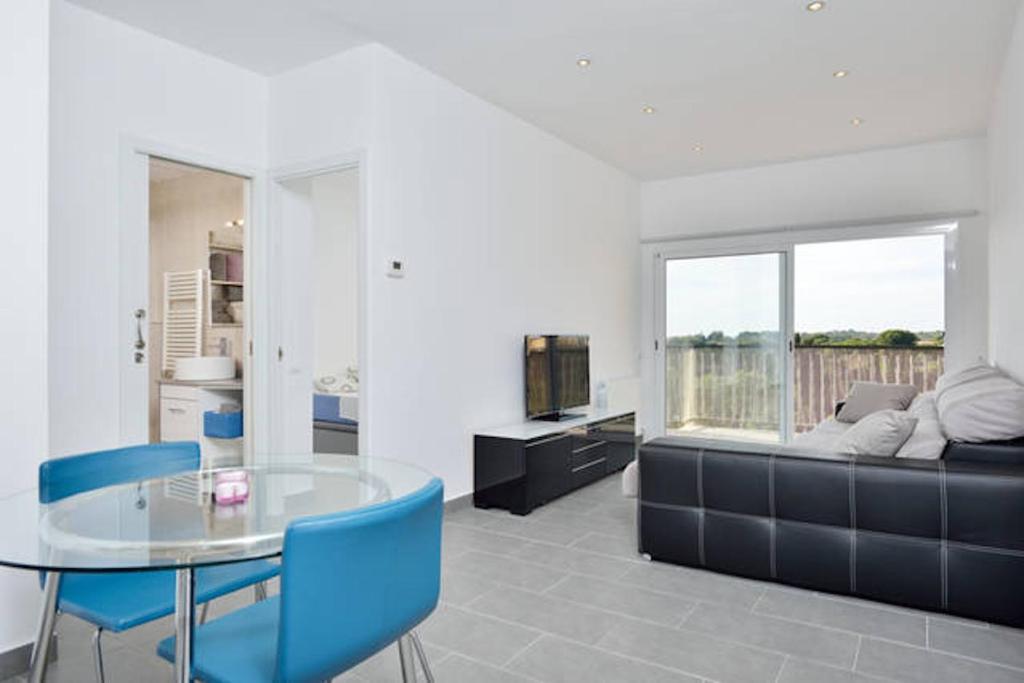 a dining room with a glass table and blue chairs at COSY WELL SITUED APARTMENT WITH SEA VIEW in Vilanova i la Geltrú