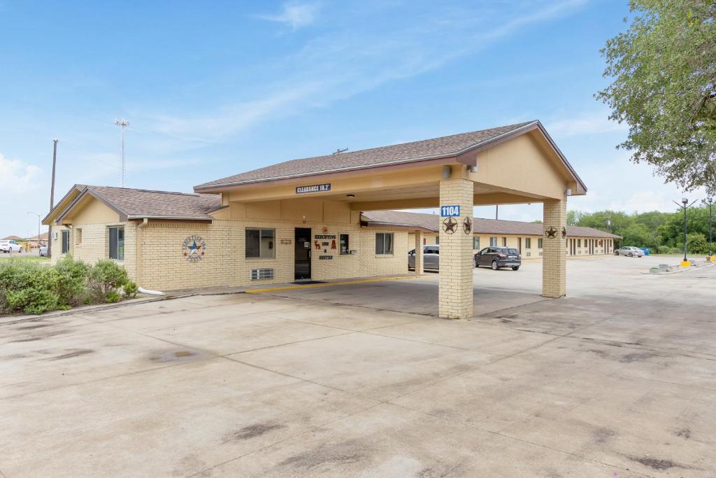 un edificio con un estacionamiento delante de él en Freer Executive Inn & Suites, en Freer