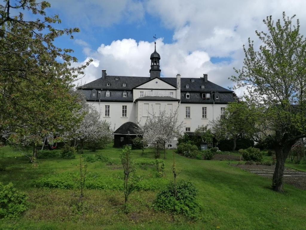 ein großes weißes Gebäude mit schwarzem Dach in der Unterkunft Rüstzeitenheim Sonnenschein in Saalburg