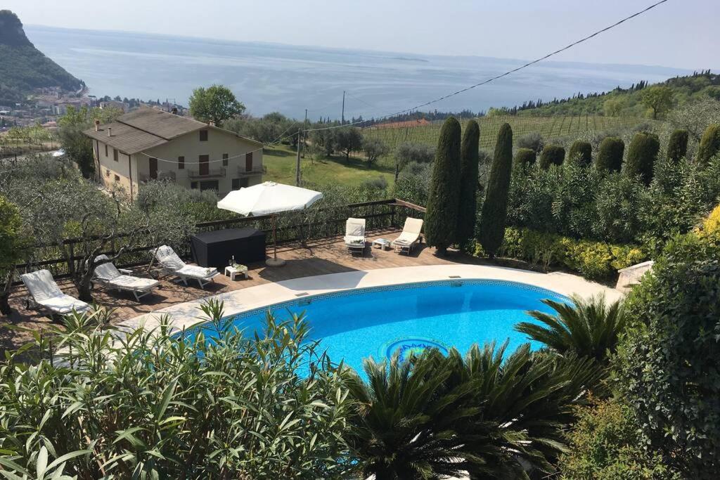 a swimming pool in a yard with a house at Villa Rosa del Garda in Garda