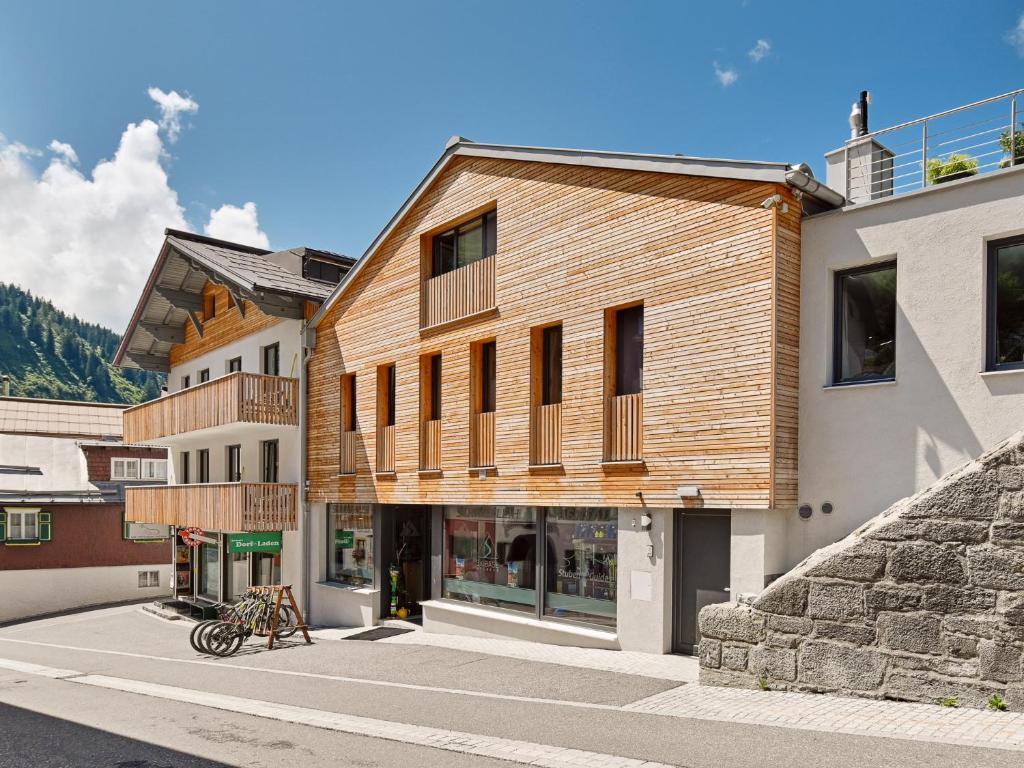 a building with wooden accents on the side of a street at Haus Flexen Appartements & Suite in Stuben am Arlberg